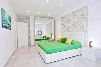 a bedroom with a large bed with green and yellow pillows at Maison Roberta San Peter in Rome