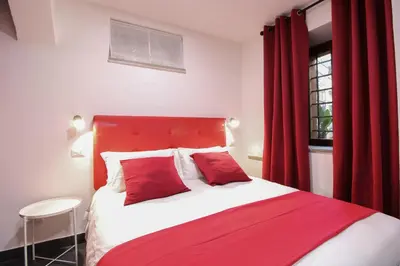 a bedroom with a red and white bed and a window at Charming Large Apartment - 3 Bedroom in Trastevere in Rome