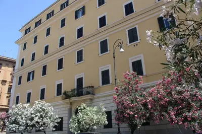 a large yellow building with flowers in front of it at Colosseum New Charming Apartment in Rome