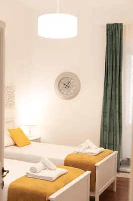 a room with two beds and a clock on the wall at Leonardo Suite Pantheon in Rome