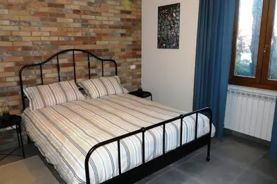 a bed in a bedroom with a brick wall at La casetta di Anastasia in Rome