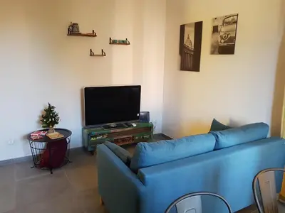 a living room with a blue couch and a tv at La casetta di Anastasia in Rome