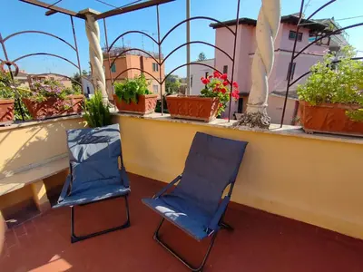 two chairs sitting on a balcony with potted plants at La casetta di Anastasia in Rome