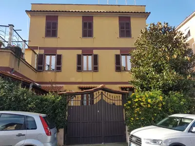 two cars parked in front of a house with a gate at La casetta di Anastasia in Rome