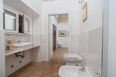 a white bathroom with a sink and a toilet at groundfloor wonderfull apartment in Rome