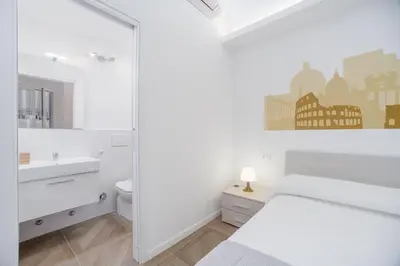 a white bedroom with a bed and a sink and a mirror at groundfloor wonderfull apartment in Rome
