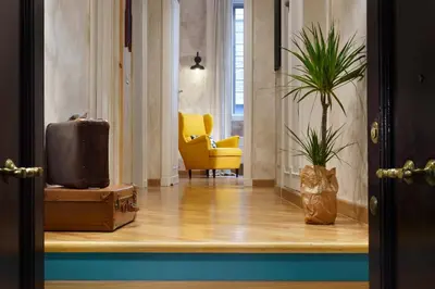 a hallway with a yellow chair and a plant at Piazza del Popolo Boutique Home in Rome