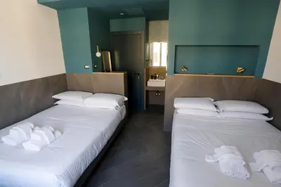 two beds in a room with a bathroom at Ottaviano Smart Rooms in Rome