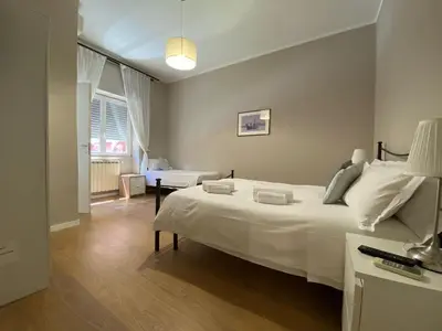 a bedroom with a large white bed and a table at èROMA - RE DI ROMA Apartment in Rome
