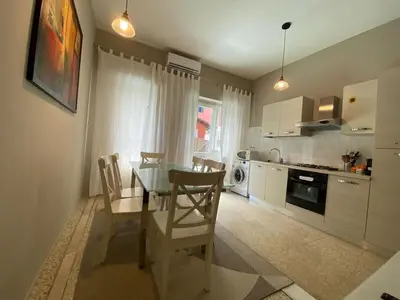 a kitchen with a table and chairs in a room at èROMA - RE DI ROMA Apartment in Rome