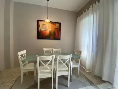 a dining room with a table and white chairs at èROMA - RE DI ROMA Apartment in Rome