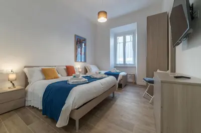 a bedroom with a bed and a flat screen tv at Roman Station House in Rome