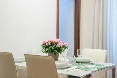 a dining room table with a vase of flowers on it at RELAIS CAVOUR 133 in Rome