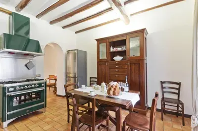 a kitchen with a table and a green stove at La Finestra su Trastevere - Appartamento 100 mq Centrale, Luminoso, Spazioso in Rome