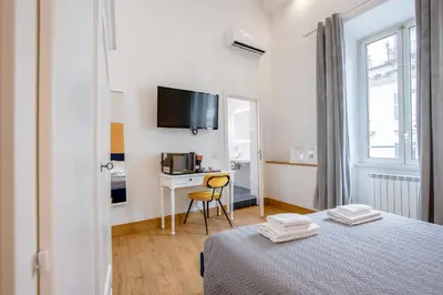 a bedroom with a bed and a desk with a computer at New Unico San Cosimato in Rome