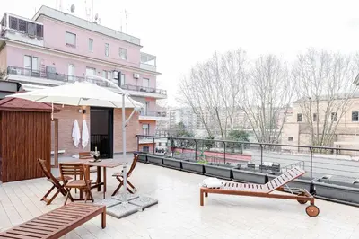 a patio with a table and chairs and an umbrella at La Suite al Vaticano in Rome