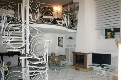 a spiral staircase in a living room with a desk at Comfortable Apartment in the Heart of Rome, 65m², City View in Rome