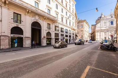a street with cars driving down a city street with buildings at Deluxe Suite Welness in Rome
