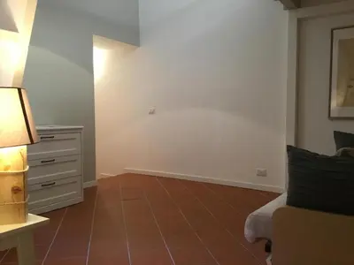 a bedroom with a bed and a dresser with a lamp at LE FATE STUDIO a San Pietro in Rome