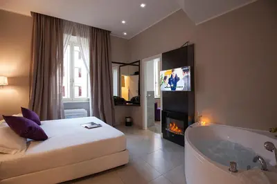 a bedroom with a white bed and a bath tub at Roman Holidays Boutique in Rome
