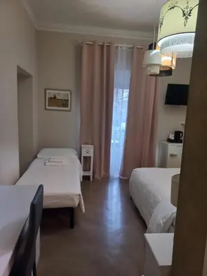 a room with two beds and a window at Stefano House Vaticano Roma in Rome