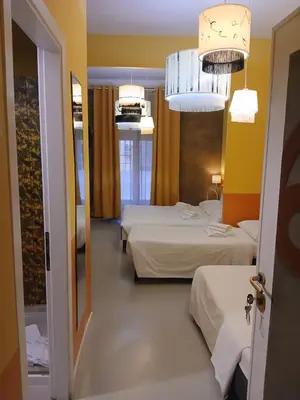 a hotel room with two beds and two chandeliers at Stefano House Vaticano Roma in Rome