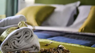 a towel sitting on a table with a bed at Home Suites Giolitti in Rome