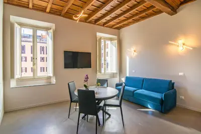 a living room with a table and a blue couch at The Pantheon Eyes in Rome