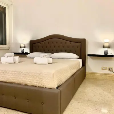 a bedroom with a large bed with towels on it at Simon's Guest House Rome in Rome