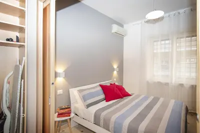 a small bedroom with a bed with a red pillow at Cosy Apartment 5 minutes from St Peter in Rome