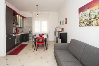 a living room with a couch and a table in a kitchen at Cosy Apartment 5 minutes from St Peter in Rome