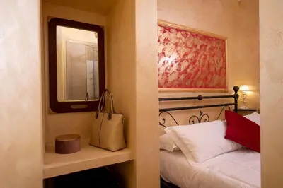 a bedroom with a bed with a mirror and a bag at Residenza Nobile Laurina in Rome