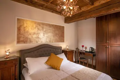 a bedroom with a bed with a chandelier and a desk at Residenza Nobile Laurina in Rome