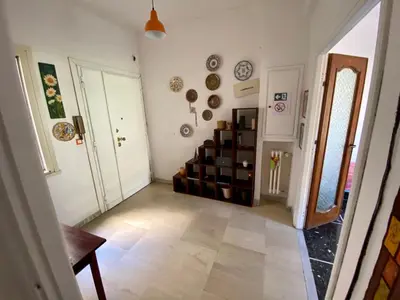 a living room with a staircase and plates on the wall at Casa Alberto in Rome