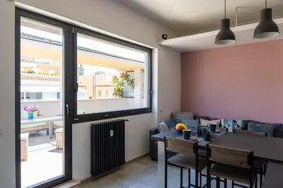 a living room with a table and a couch at Penthouse with Panoramic Terrace -3 Min to Metro A in Rome