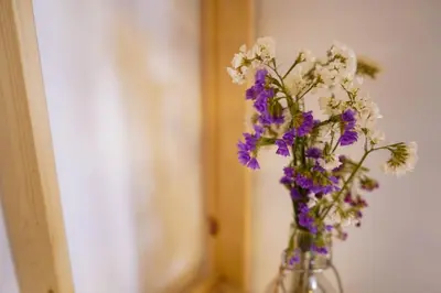 a glass vase filled with purple and white flowers at The Good Place B&B in Rome