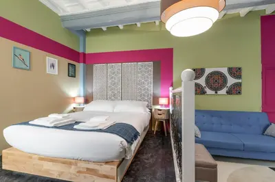 a bedroom with a bed and a blue couch at Rome As You Feel - Torre Design Apartment in Rome