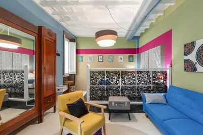 a living room with a blue couch and colorful walls at Rome As You Feel - Torre Design Apartment in Rome