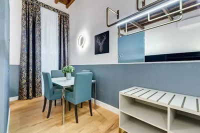 a dining room with a table and blue chairs at Glamour Studio - Spanish Steps in Rome