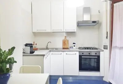 a white kitchen with white cabinets and a stove at STEFY ROME APARTMENT in Rome