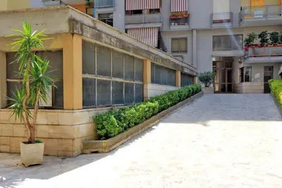 a building with palm trees in front of it at Bed and Breakfast La Stazione Del Vaticano in Rome