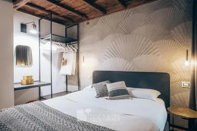 a bedroom with a bed and a wall with patterns at Restart Accommodations Rome in Rome