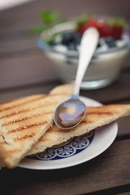 a spoon of peanut butter on a plate with toast at Le Tare B&B in Rome
