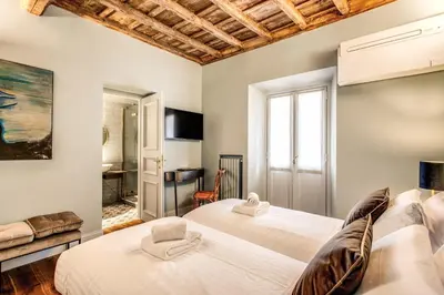 a bedroom with two beds and a desk at Febo Decharm apartment in Rome