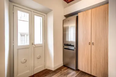 a kitchen with a refrigerator and a window at Febo Decharm apartment in Rome