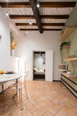 a living room with a table and chairs and a bedroom at Sofia alla VII Coorte in Rome