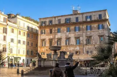 two people standing in front of a fountain in front of a building at Sofia alla VII Coorte in Rome