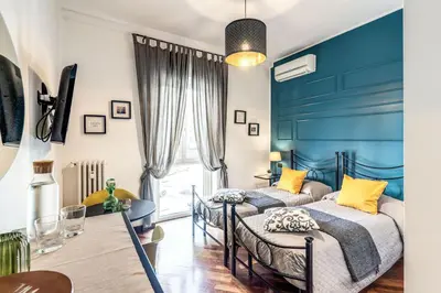 two beds in a room with blue walls at Stasera a casa da M.E. in Rome