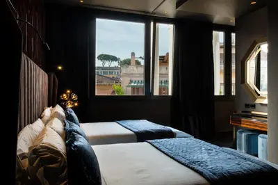 two beds in a room with a window at U-Visionary Roma Hotel in Rome