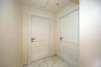 a white room with two doors and a marble floor at La Maisonnette Tritone Trevi Apartment Rome in Rome